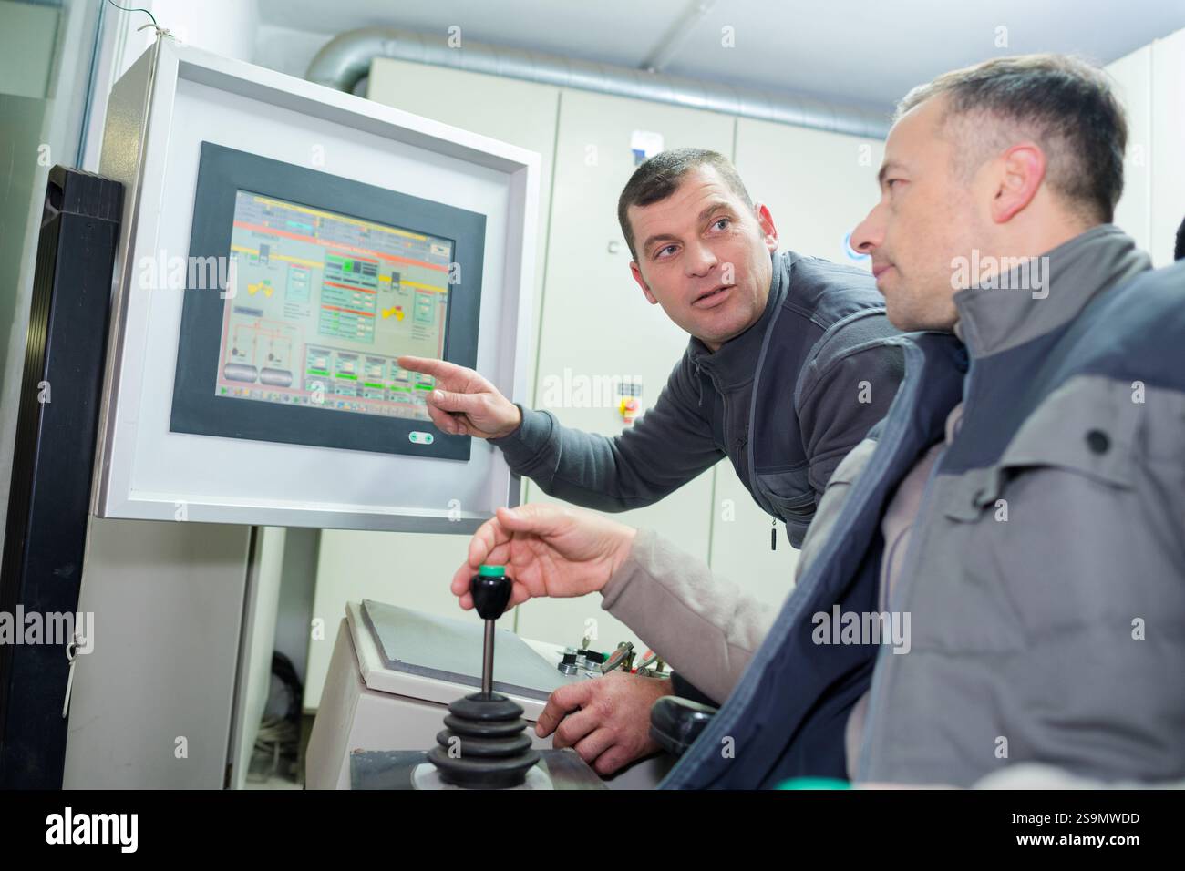colleghi industriali che consultano monitor di computer Foto Stock