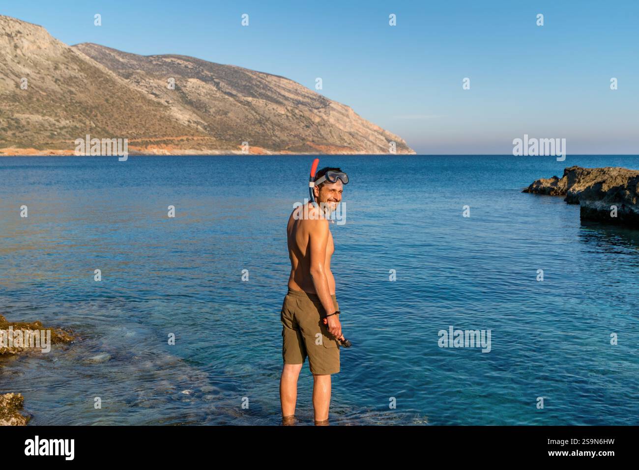 Vista posteriore di un uomo con equipaggiamento per immersioni sul mare Foto Stock