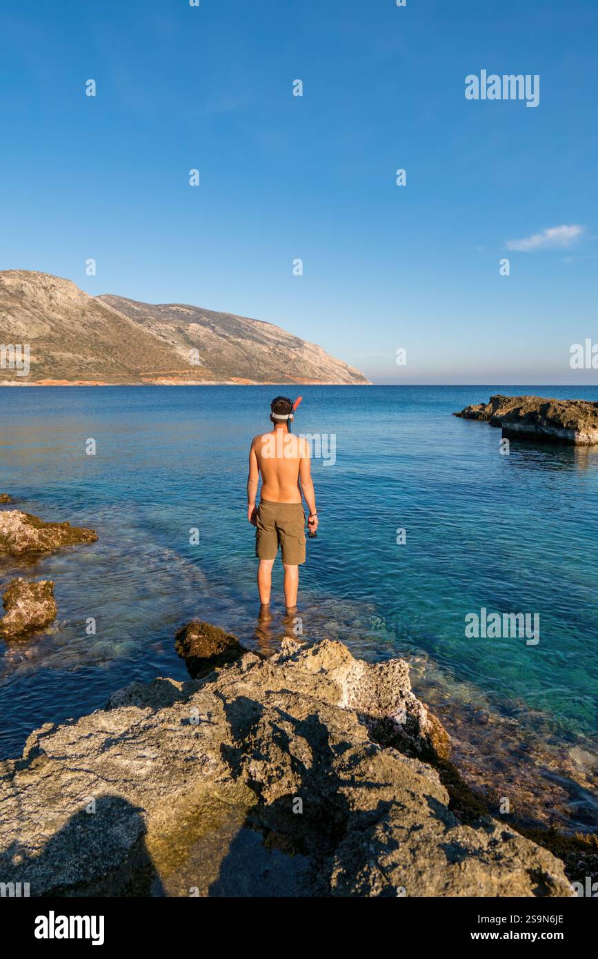 Vista posteriore di un uomo con equipaggiamento per immersioni sul mare Foto Stock