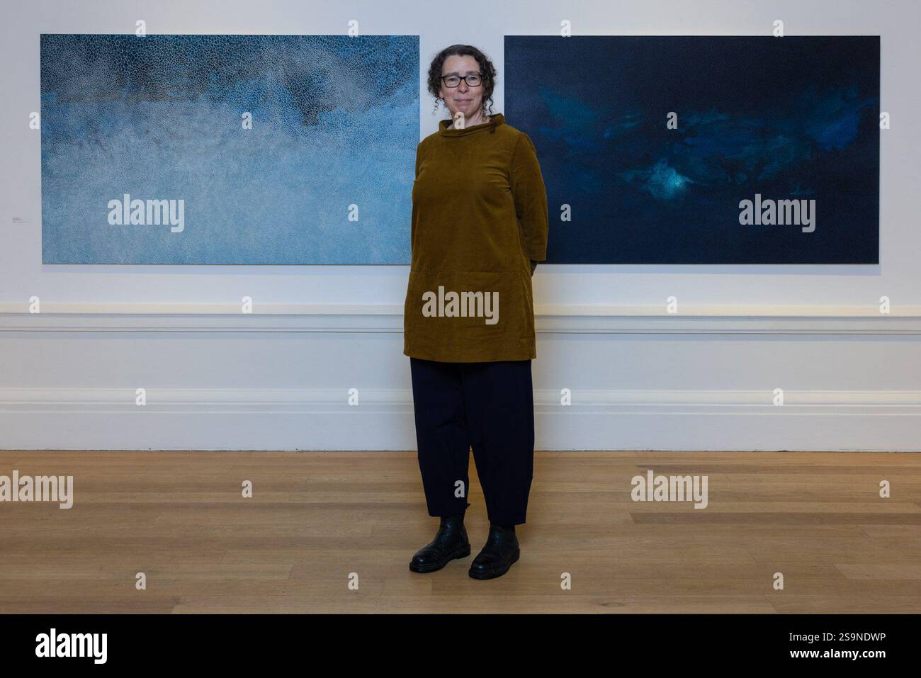 Città di Edimburgo, Regno Unito. 27 gennaio 2025 nella foto: Artista, Samantha Clark, tra due delle sue opere su larga scala, This Salted Light, 2024 e Cloud, Moon, Wave, 2024. la Royal Scottish Academy presenta in Orcadia, una mostra di opere d'arte ispirate al paesaggio e all'ambiente naturale delle Orcadi. La mostra include un nuovo corpo di opere di Samantha Clark, la vincitrice inaugurale del RSA MacRobert Art Award for Painting. La mostra si svolge dal 25 gennaio al 2 marzo presso le RSA Galleries on the Mound di Edimburgo (NB - la chiamata è stata posticipata al 27 gennaio a causa della tempesta Eowyn). Cred Foto Stock