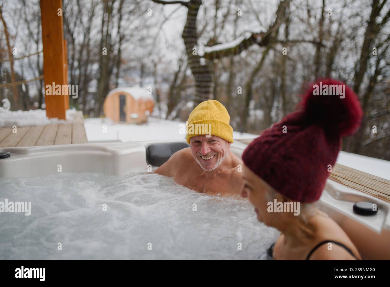 Coppia senior che usa una vasca idromassaggio. Concetto di fuga per il weekend di San Valentino. Foto Stock