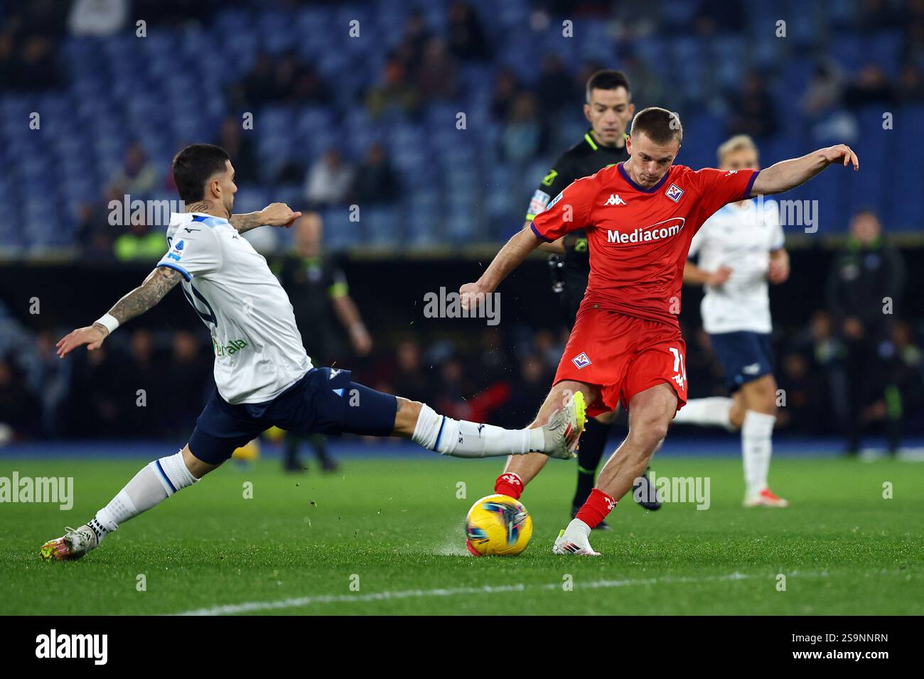 Roma, Italia. 26 gennaio 2025. Albert Gudmundsson della Fiorentina calcia il pallone sotto pressione di Mattia Zaccagni della Lazio durante i campioni d'Italia Foto Stock