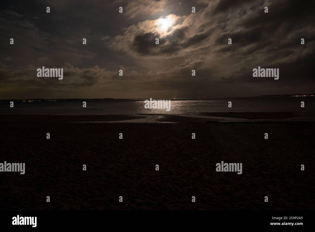 Vista della luna piena con nuvole, la luce si riflette nel Mar Baltico vicino a Glücksburg nell'autunno 2021 Foto Stock