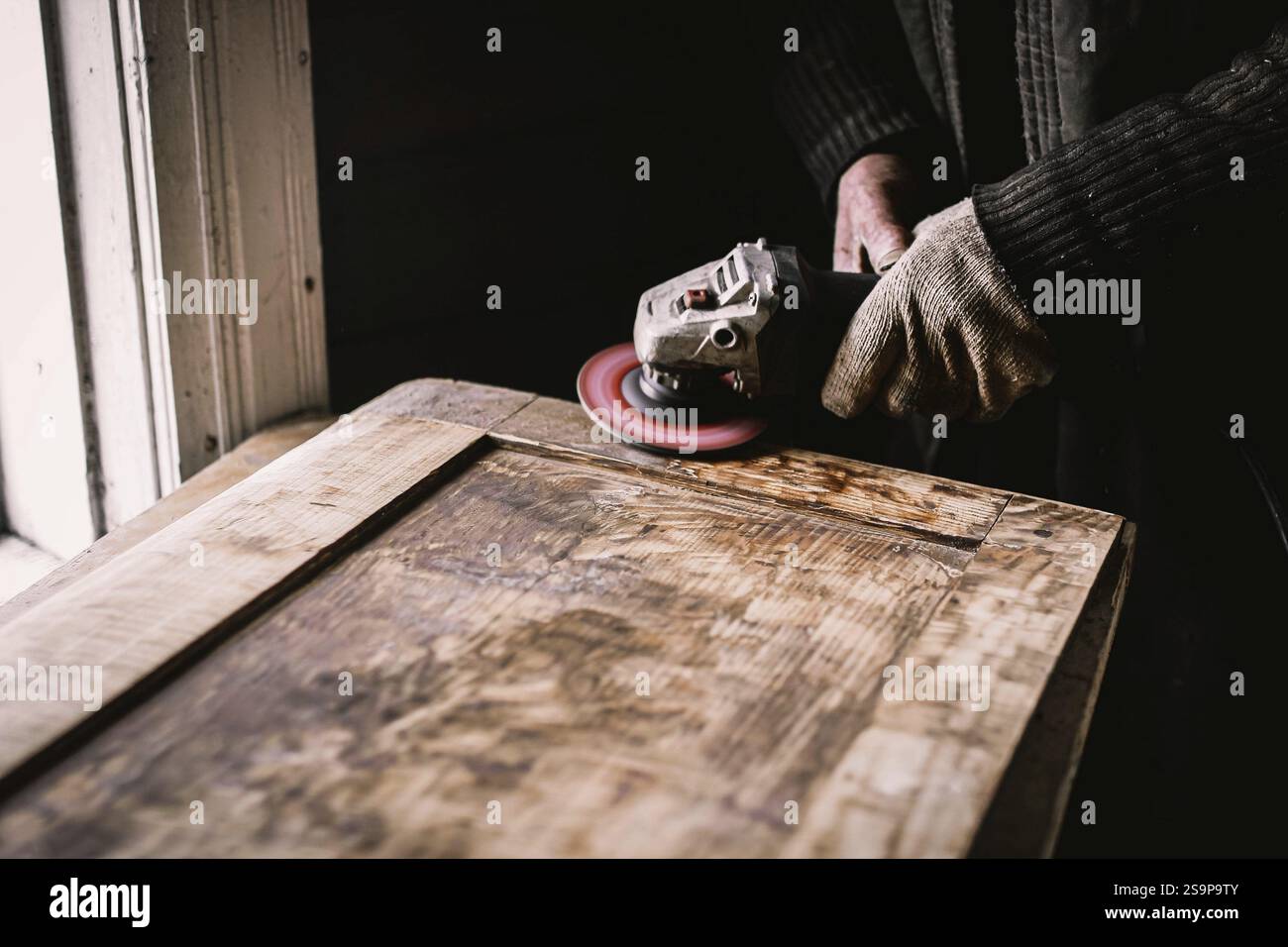 Vista ravvicinata delle mani utilizzando un attrezzo elettrico per la lavorazione del legno Foto Stock