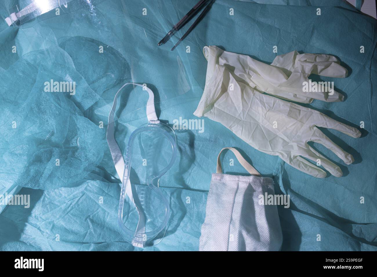 Attrezzatura di protezione medica, tra cui occhiali, guanti e maschera su una superficie di ottanio Foto Stock