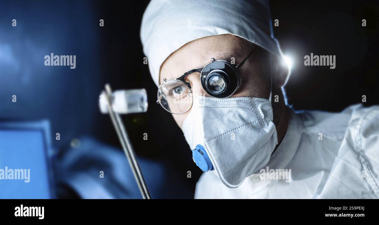 Un chirurgo cova intensamente sopra una maschera, tenendo gli strumenti medici, con un punto luminoso illuminante Foto Stock