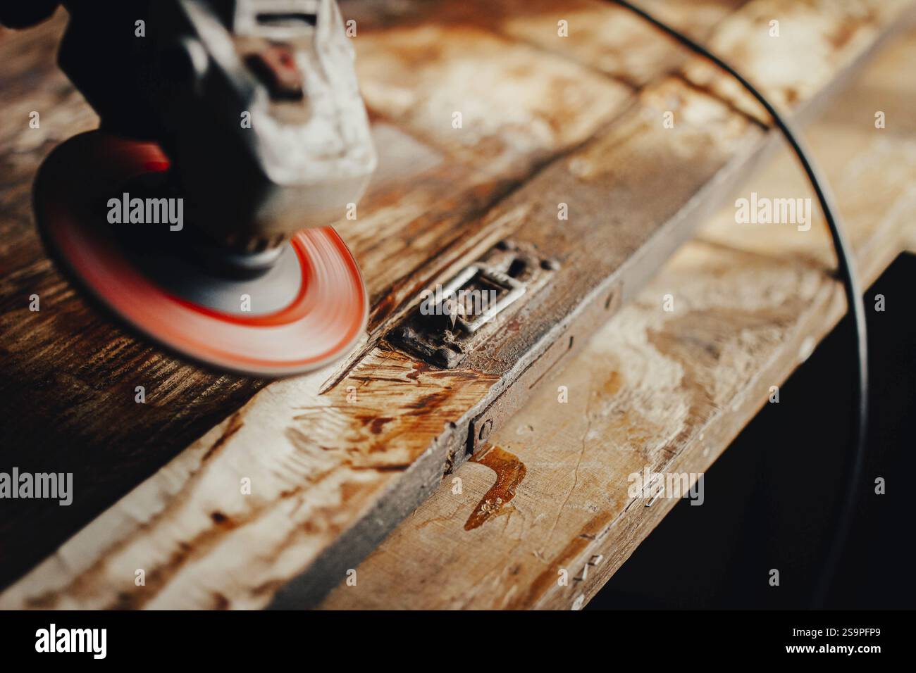 Smerigliatrice angolare per levigare una superficie in legno con consistenza visibile e dettagli di invecchiamento Foto Stock