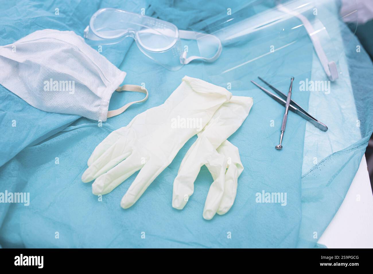 Dispositivi di protezione medica, compresi guanti e una maschera su una superficie di ottanio Foto Stock