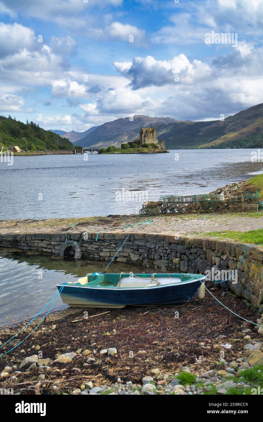 Guardando verso sud lungo Loch Duich fino al castello di Eilean Donan, accanto alla strada principale A87 per Skye. Barca sullo scalo. Morvich, Highlands occidentali, Scozia, Regno Unito Foto Stock