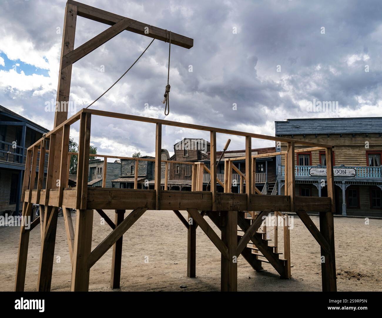 Una struttura a forca in legno in una città occidentale deserta, caratterizzata da un cappio e scale, sotto un cielo nuvoloso. Foto Stock