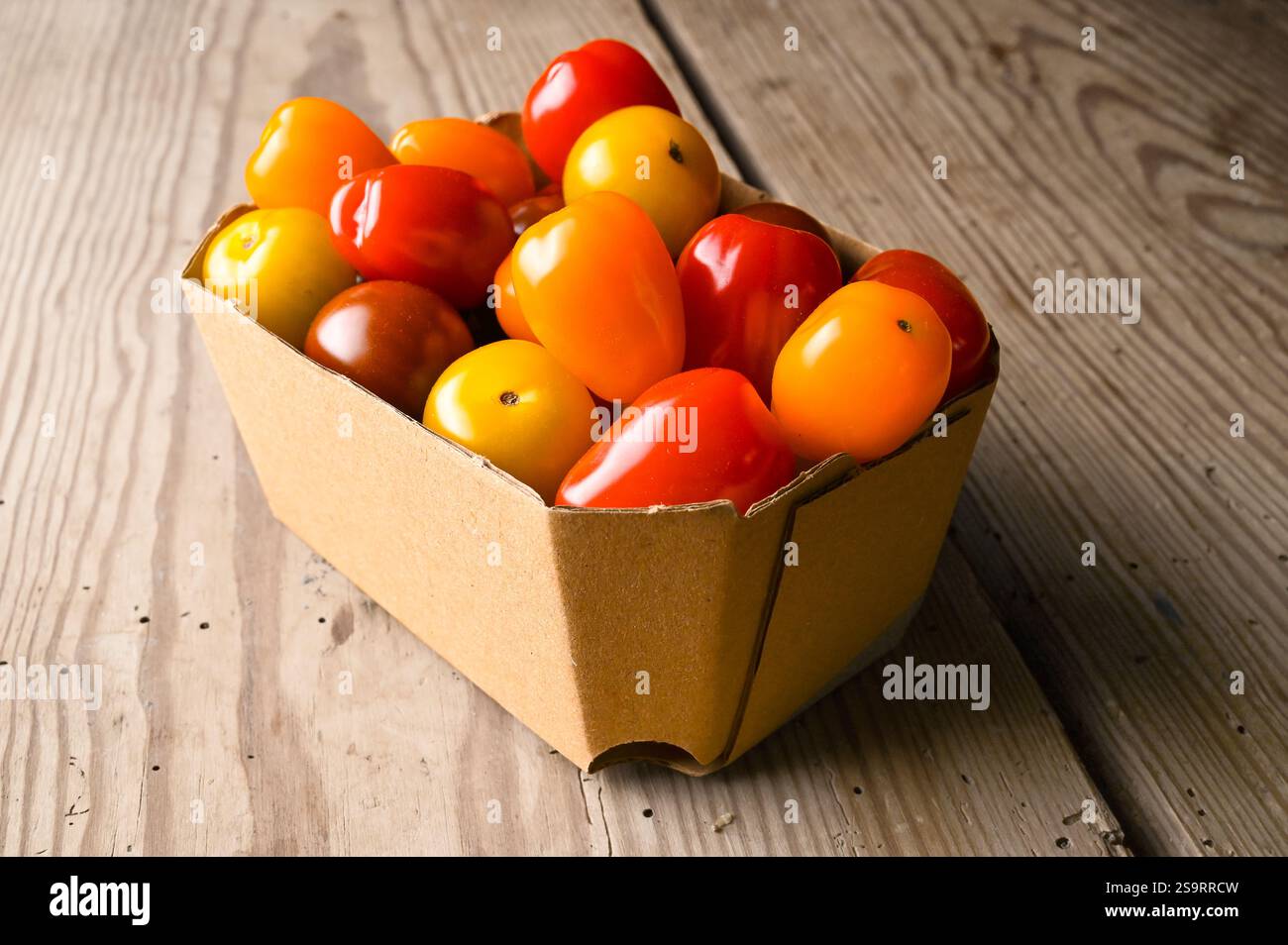 Pomodori da cocktail biologici freschi provenienti dal mercato in imballaggi di cartone riciclabili. Foto Stock