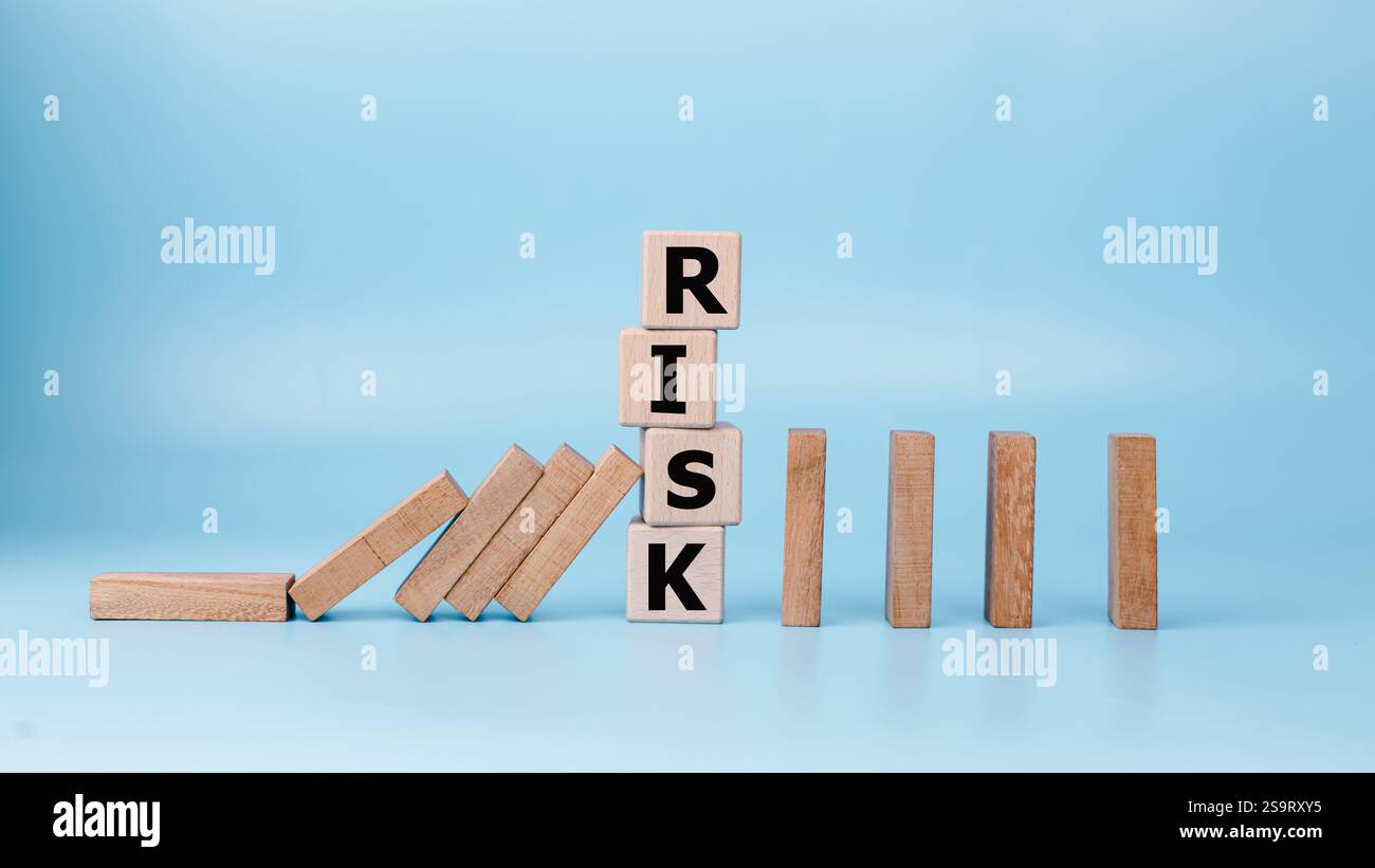 Concetto di gestione DEL RISCHIO e di effetto domino, impostato da blocchi di legno su sfondo azzurro, crisi finanziaria, economia, concetto di gestione del rischio aziendale Foto Stock