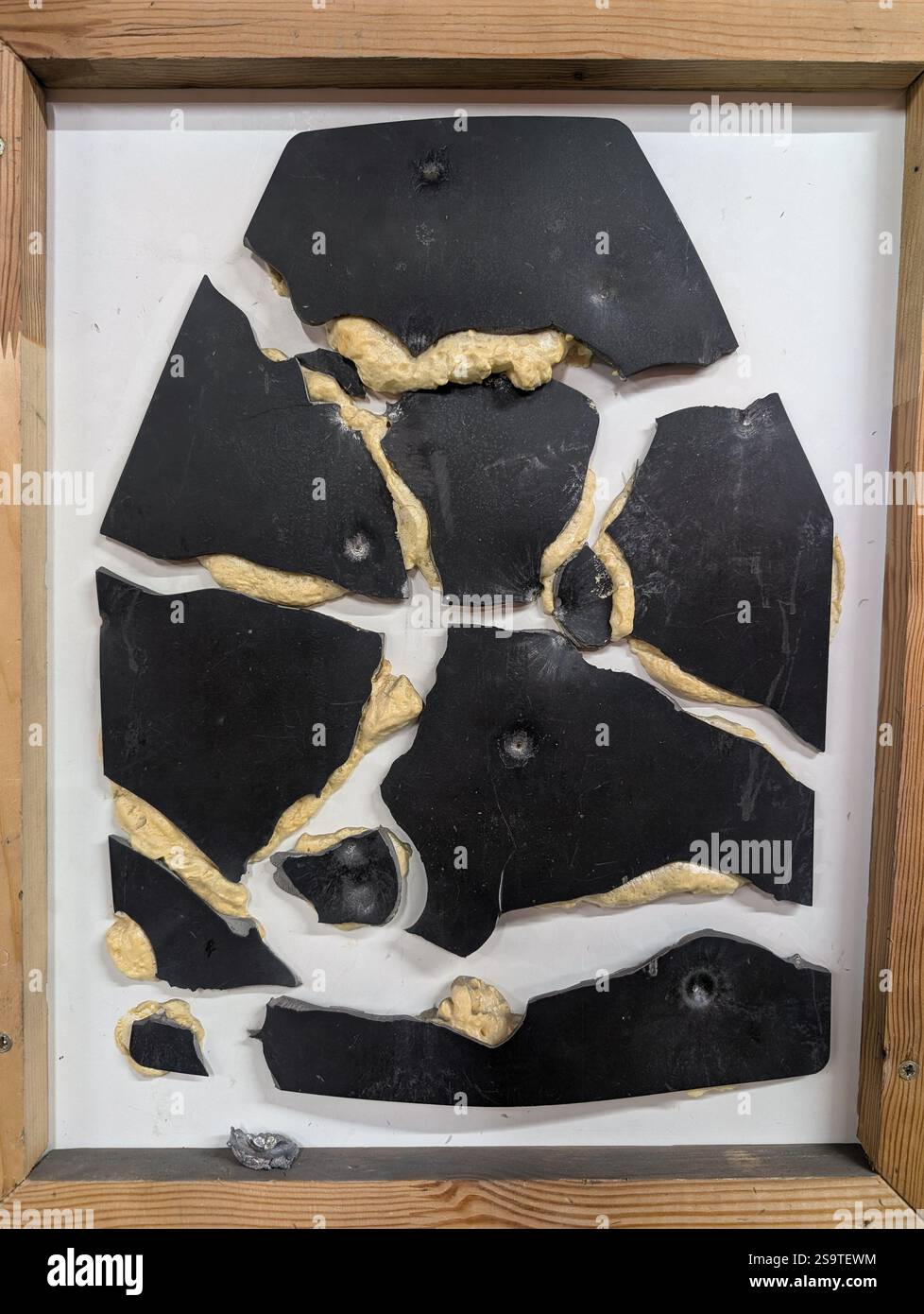Piastra corazzata in acciaio da giubbotto antiproiettile militare spaccata dopo il test di penetrazione con calibri diversi. Protezione del corpo da soldato. Foto Stock