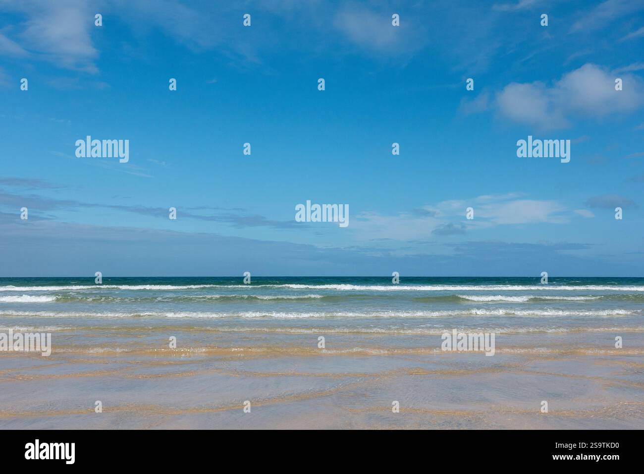 Cieli azzurri e onde dolci su una spiaggia di sabbia della Cornovaglia a Porthkidney Beach, Cornovaglia, Inghilterra, Regno Unito Foto Stock