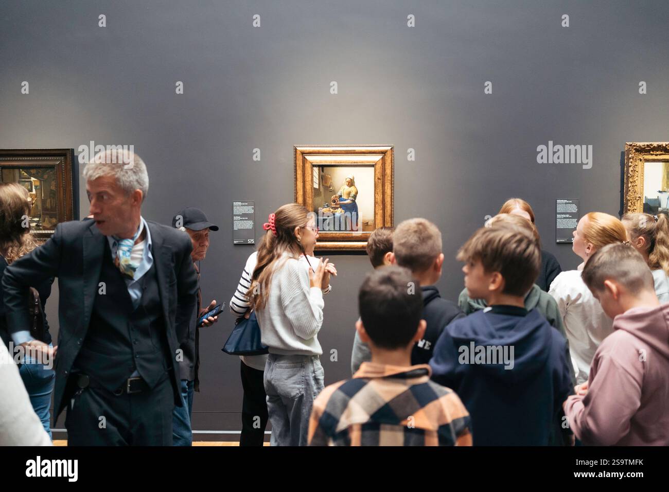 Gruppo di persone, soprattutto bambini che ammirano il famoso dipinto "donna che versa latte" di Johannes Vermeer al Rijksmuseum Foto Stock