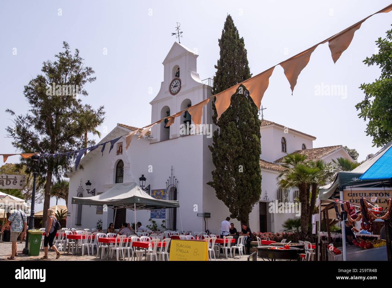 Splendida facciata bianca della chiesa di Iglesia Santo Domingo de Guzman durante i preparativi per il tradizionale festival gastronomico a Benalmadena Pueblo, Spagna Foto Stock