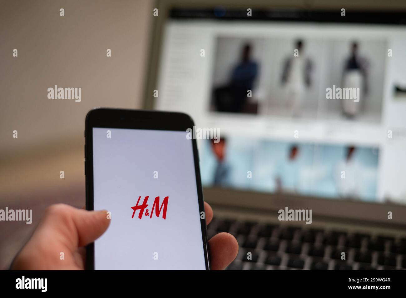 Una persona sta aprendo l'app H&M Storet su un telefono. H&M è una multinazionale svedese di abbigliamento al dettaglio. Foto Stock