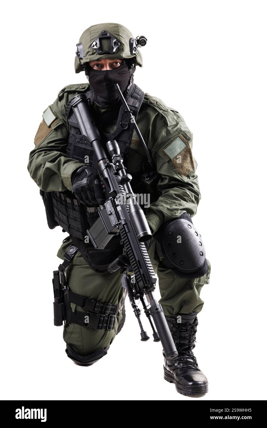 Agenti delle forze speciali che indossano equipaggiamento tattico completo e sono equipaggiati con un fucile, catturando l'essenza della moderna professionalità militare in ginocchio Foto Stock