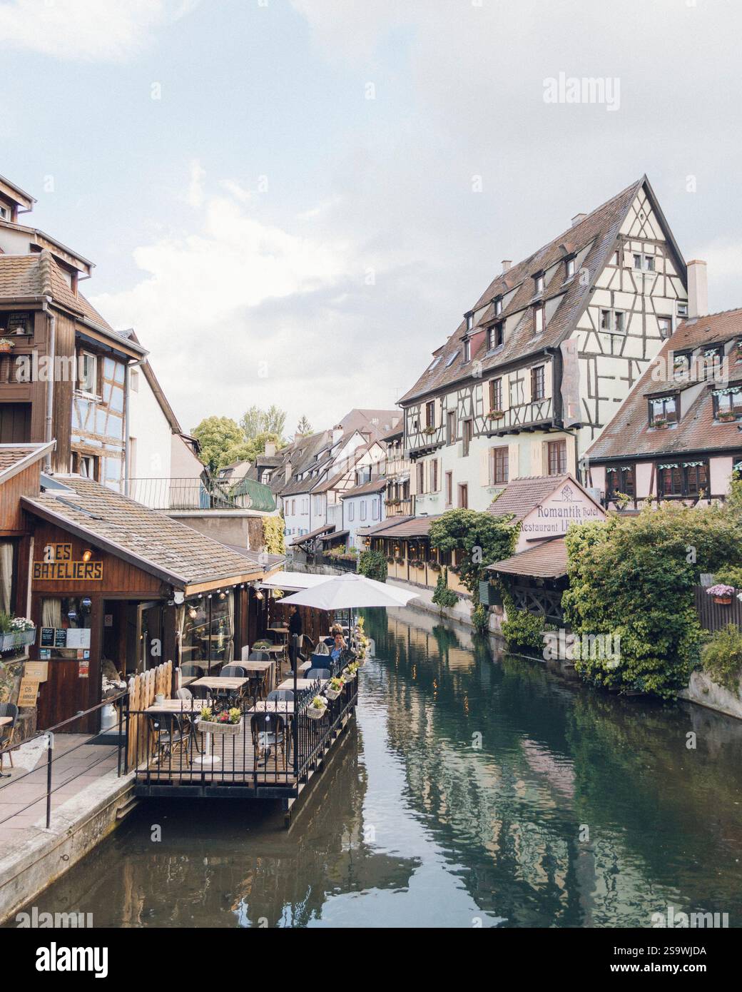 Una vista tranquilla e pittoresca del canale di Colmar, in Francia, con affascinanti edifici colorati che costeggiano il corso d'acqua. Foto Stock