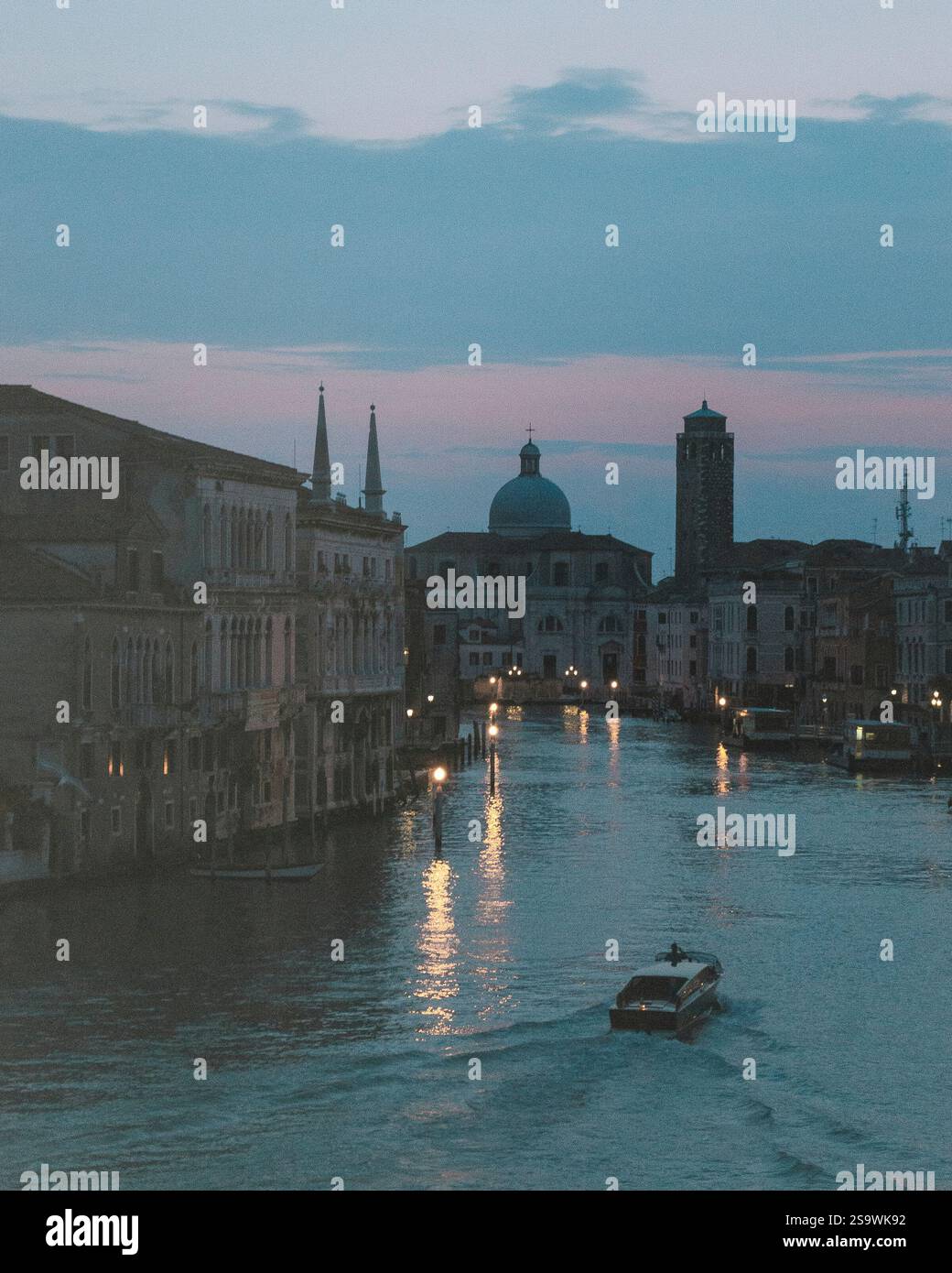 Incantevole fotografia di una barca che scivola lungo il Canal grande a Venezia, in Italia, durante le ore serali. Foto Stock