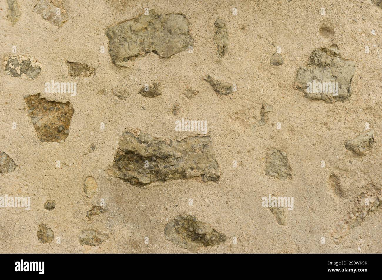 Pareti di fango incrinate con texture in pietre incorporate Foto Stock