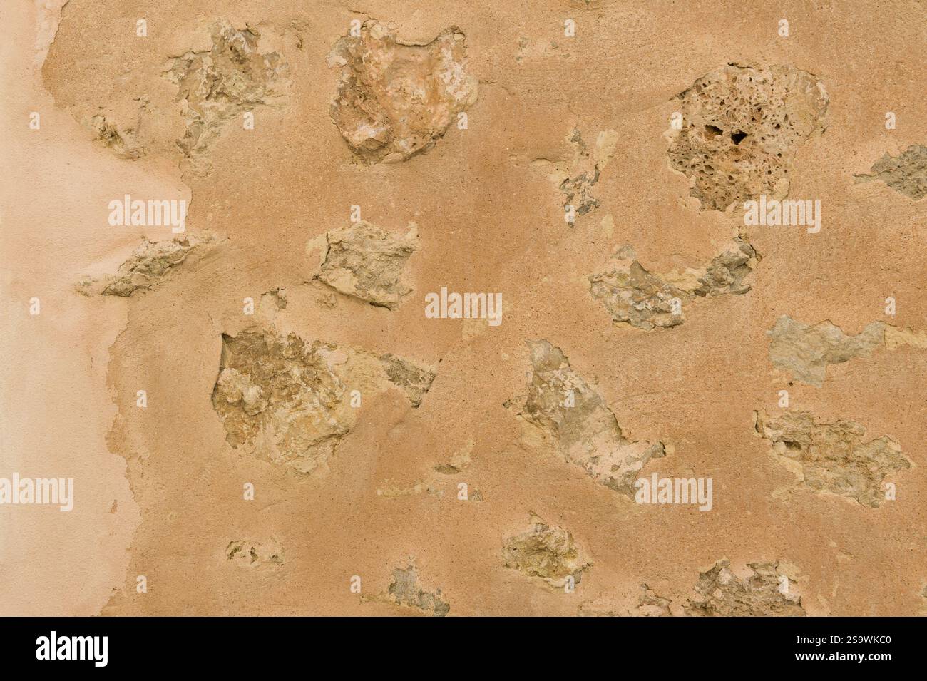 Pareti di fango incrinate con texture in pietre incorporate Foto Stock