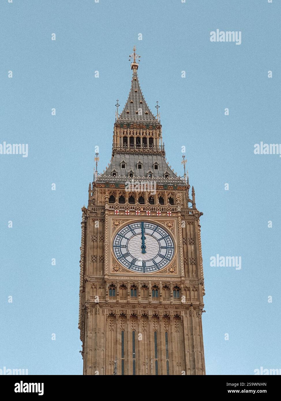 Foto ravvicinata del Big Ben, l'iconica torre dell'orologio di Londra, immersa nella calda luce dorata di un tramonto. Foto Stock