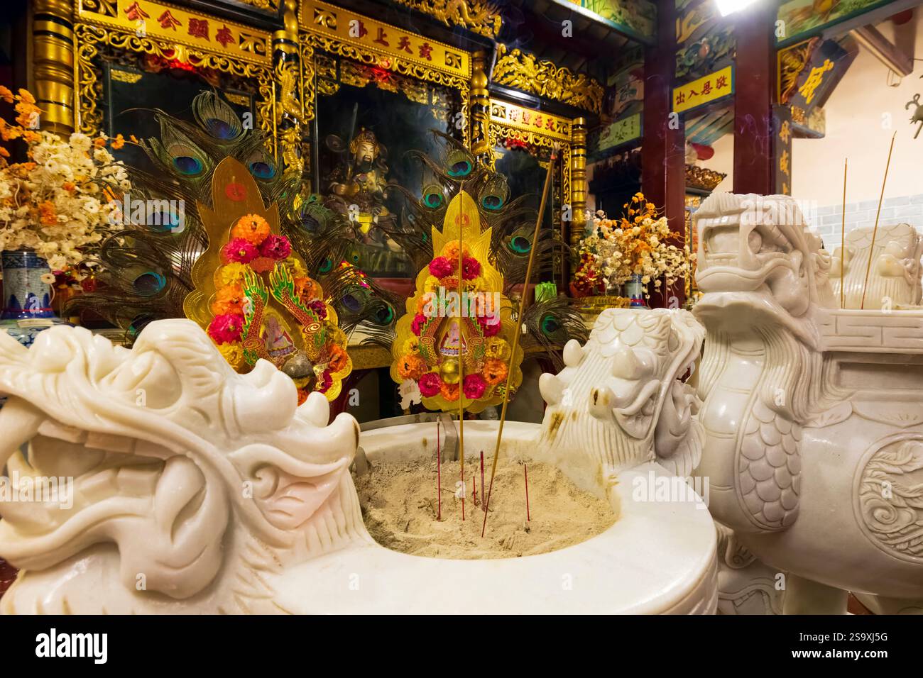 Vietnam. Tempio con altare tradizionale basato sul disegno del drago con bastoncini di incenso. Foto Stock