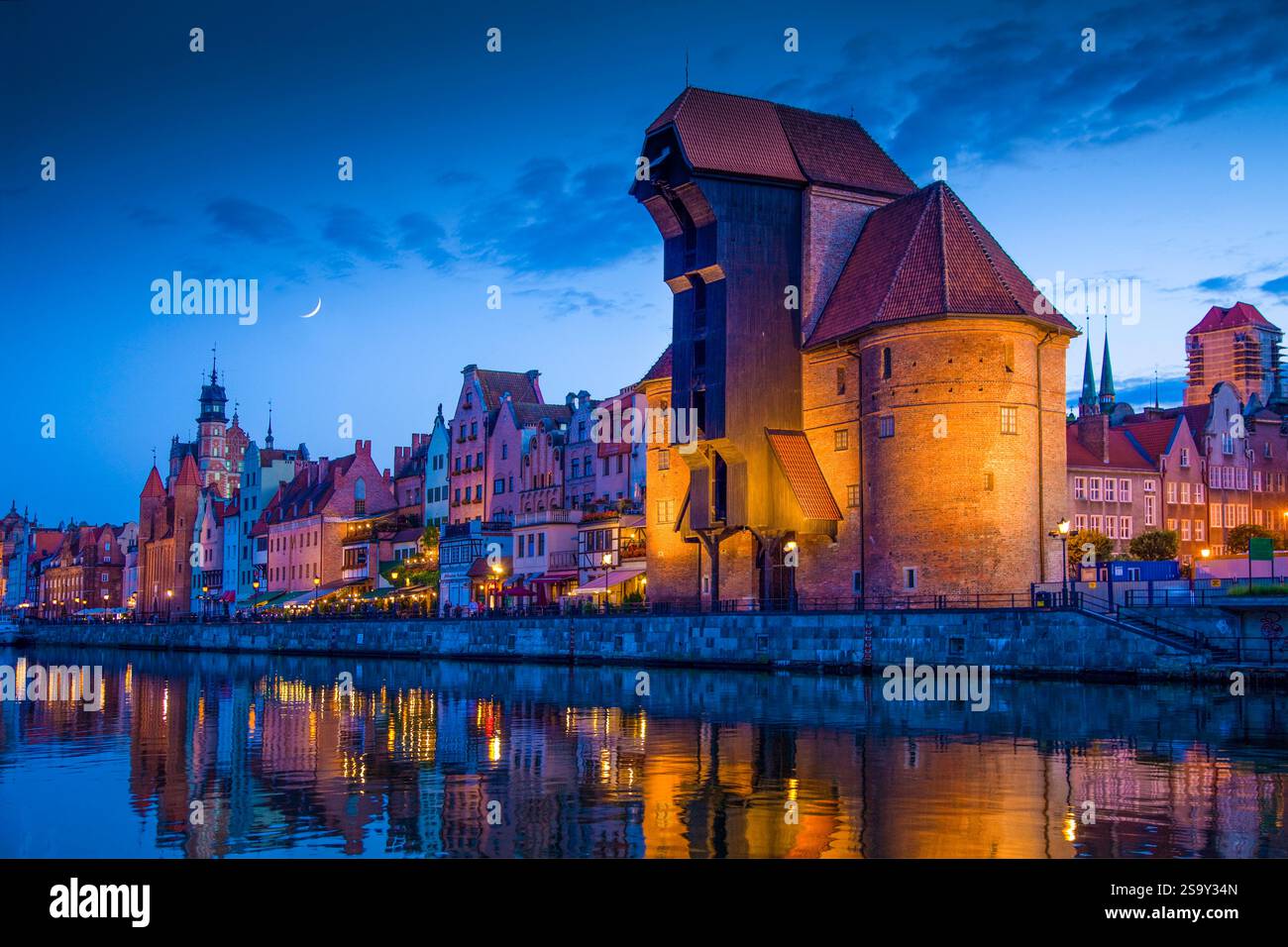 Europa, Polonia, Danzica. Edifici compositi lunari e urbani che si riflettono sul fiume al tramonto. Foto Stock