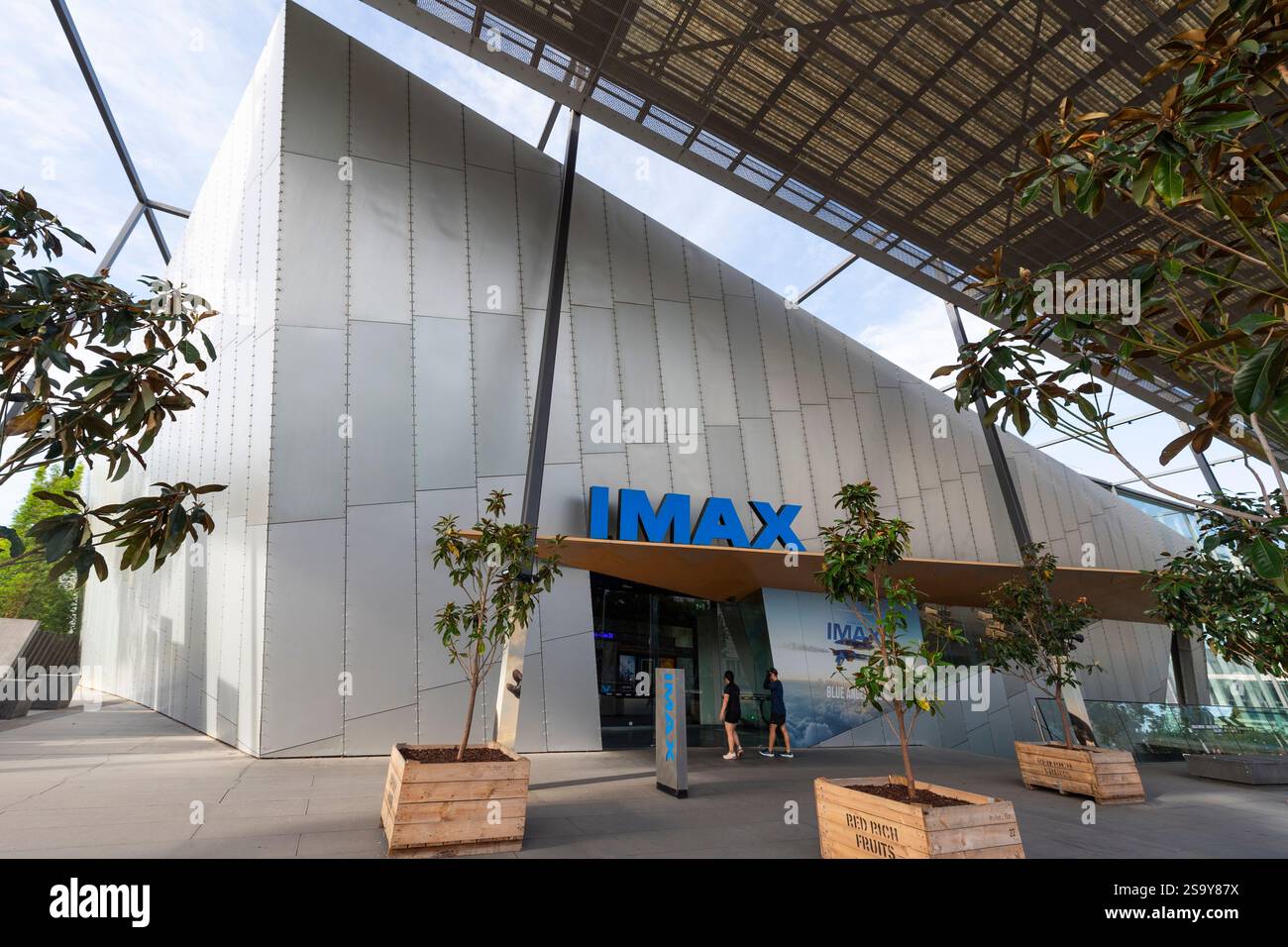I visitatori camminano sotto il tetto spiovente, l'architettura suggestiva e l'esterno argentato, con una forte angolazione, nell'edificio del cinema IMAX di Melbourne, Australia Foto Stock