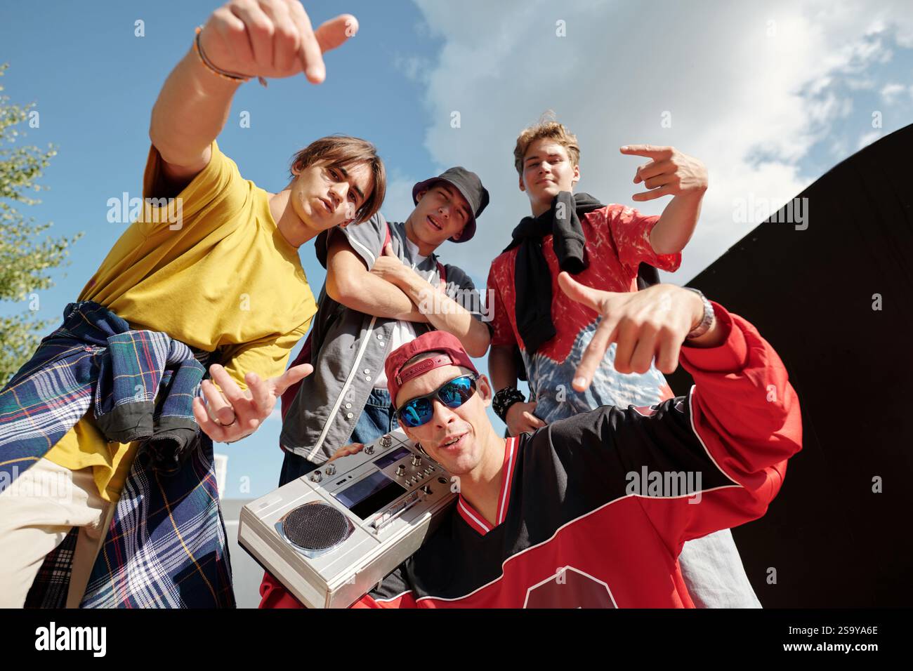 Un gruppo di amici che posa con Boom Box all'aperto Foto Stock