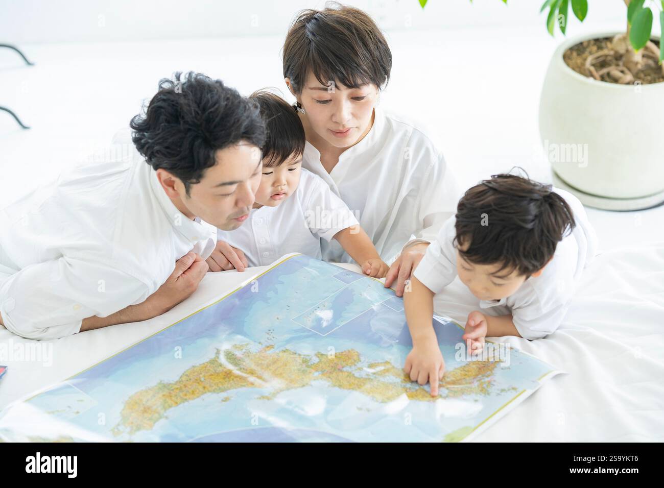 Genitori e bambini che si divertono a studiare con una mappa / genitori e bambini che pianificano un viaggio con una mappa Foto Stock