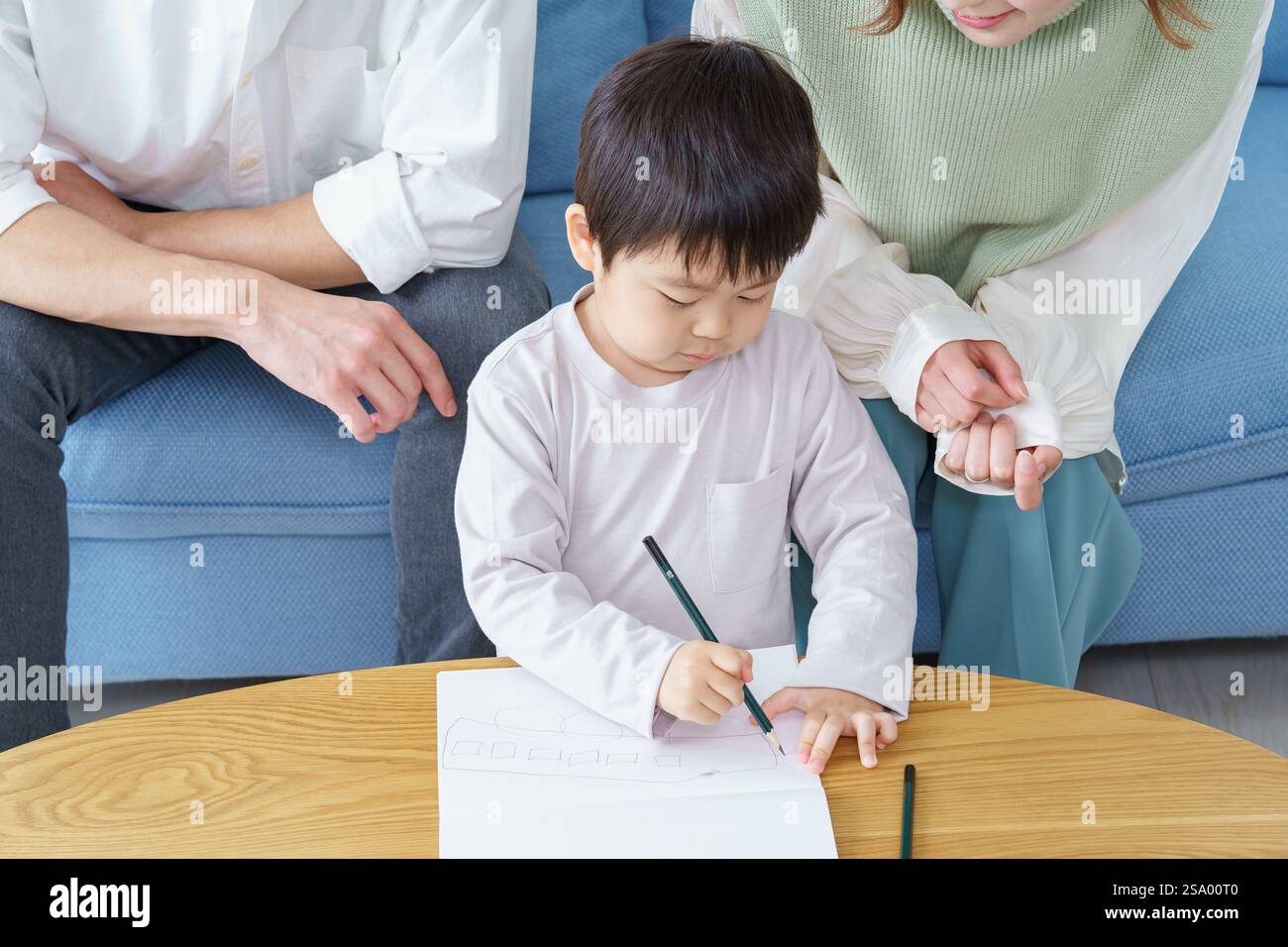 Ragazzo che disegna con matita e genitori che guardano Foto Stock