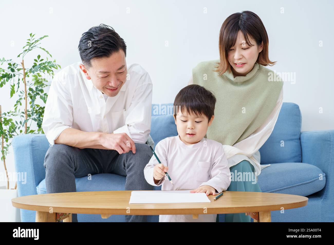 Ragazzo che disegna con matita e genitori che guardano Foto Stock