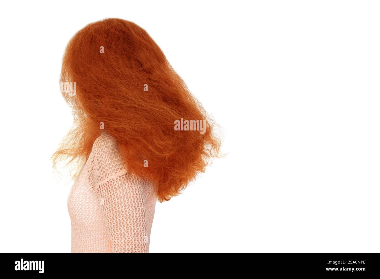 Una donna con i capelli rossi è in piedi davanti a uno sfondo bianco. I capelli sono disordinati e poco chiassosi, dando l'impressione di un abbigliamento spensierato e rilassato Foto Stock