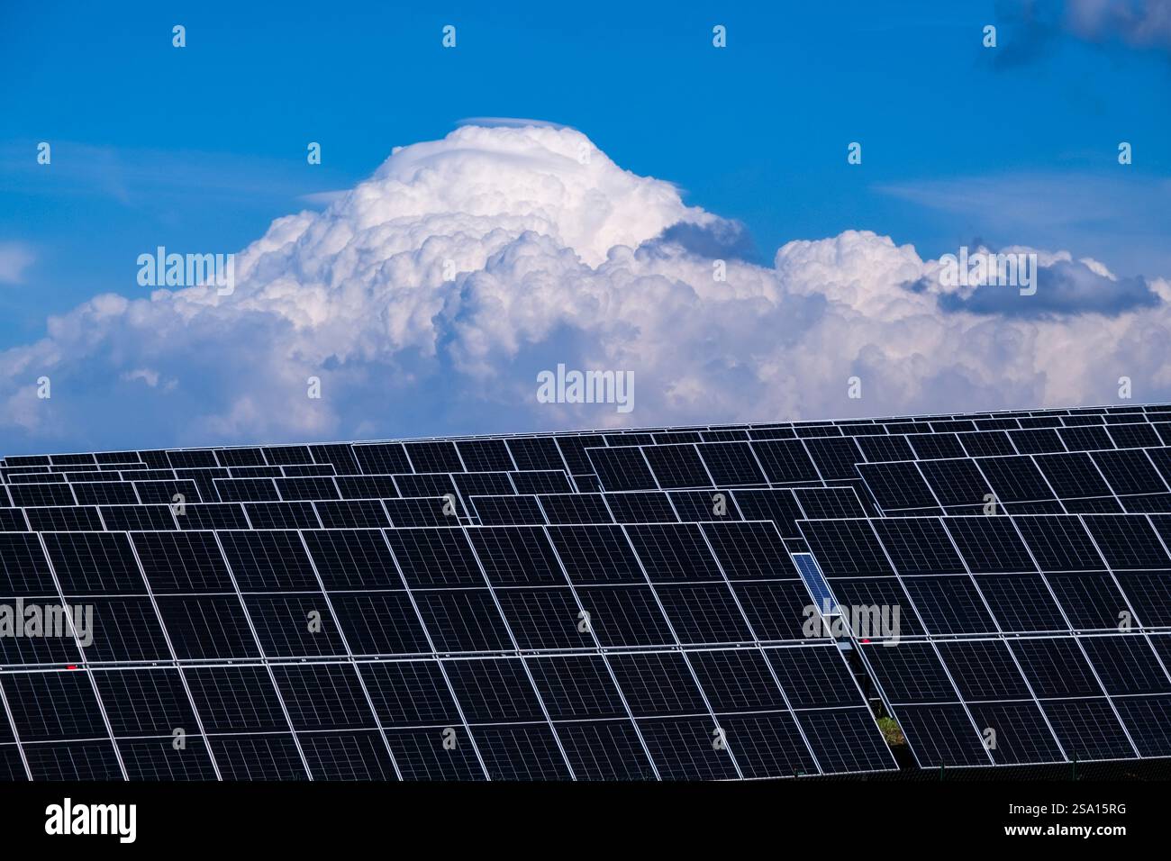 Pannelli solari e una grande nuvola di tempesta che si innalza nel cielo. Foto Stock