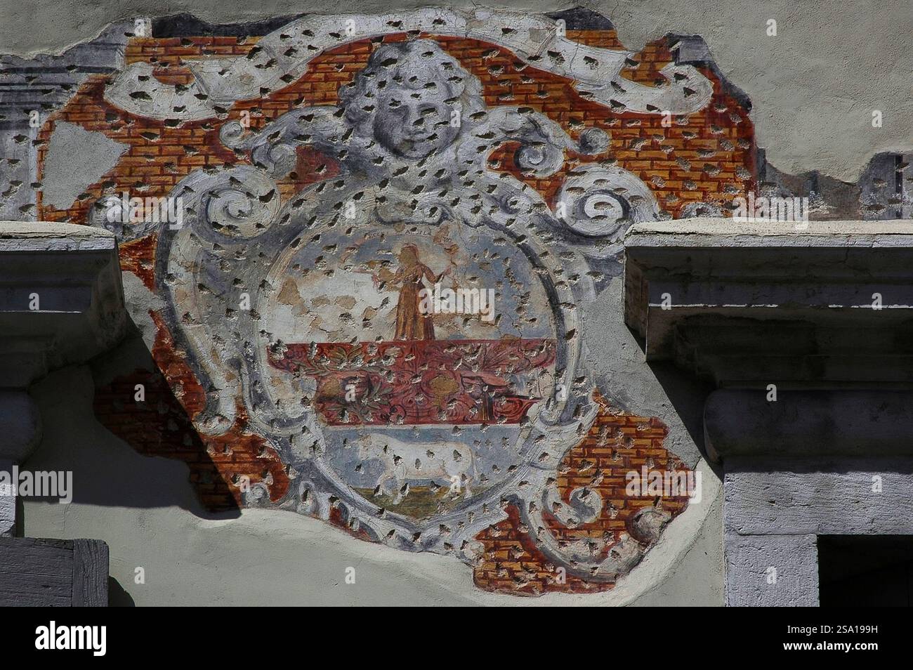 Affresco esterno frammentario con buchi, tipico di estesi danni da esplosione della prima guerra mondiale, a Rovereto, Trentino-alto Adige, Italia. Foto Stock