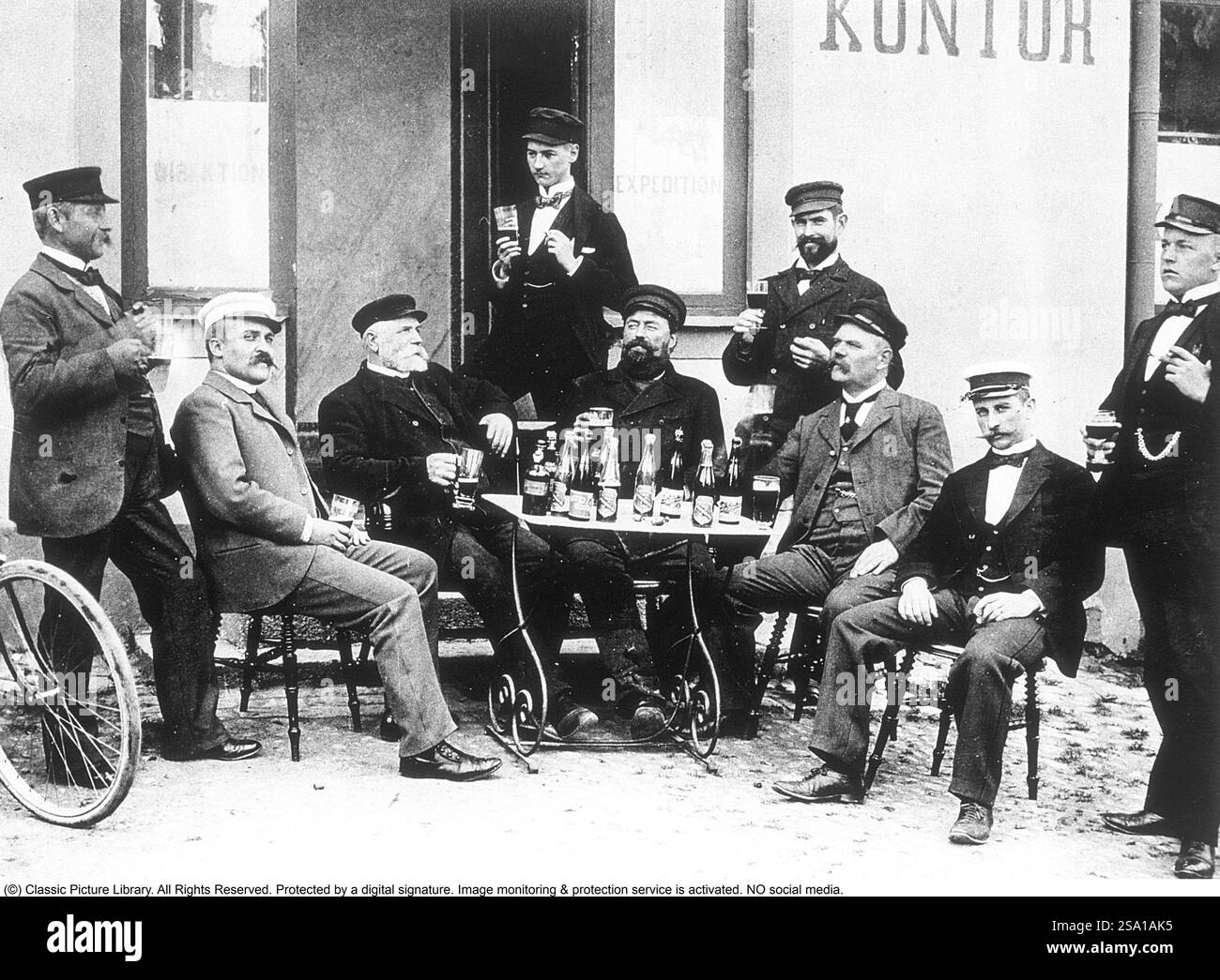 Lo stile di vita degli uomini all'inizio del XX secolo. Un gruppo di uomini è seduto a un tavolo fuori a gustare un bicchiere di birra. Sono tutte e tre in genere ben vestite e i cappelli sono accesi. Le bottiglie di birra si vedono sul tavolo. Svezia 1800-1900 BV67-5 Foto Stock Lo stile di vita degli uomini all'inizio del XX secolo. Un gruppo di uomini è seduto a un tavolo fuori a gustare un bicchiere di birra. Sono tutte e tre in genere ben vestite e i cappelli sono accesi. Le bottiglie di birra si vedono sul tavolo. Svezia 1800-1900 BV67-5 Foto Stock
