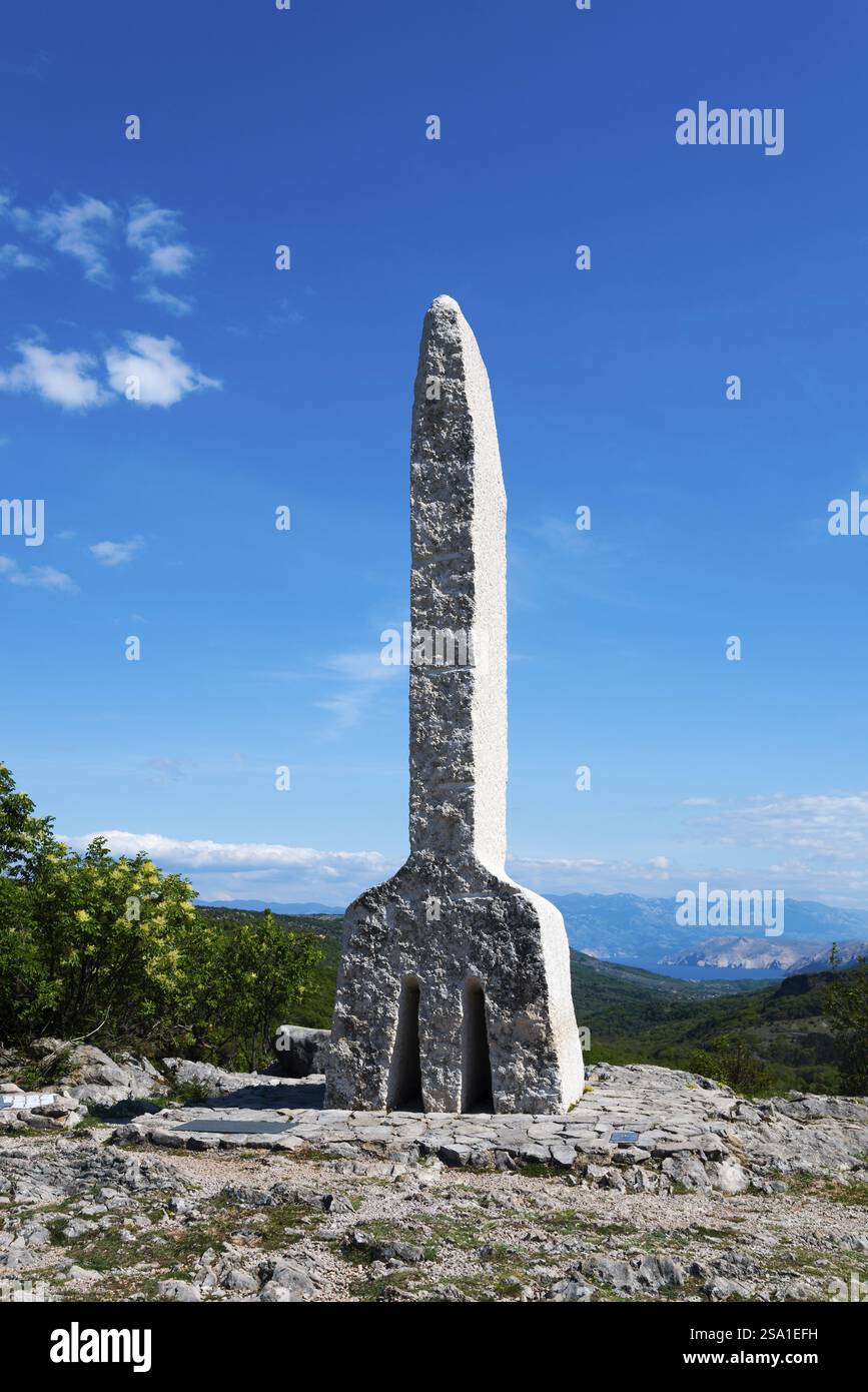Pilastro di pietra in un paesaggio boscoso che si innalza contro un cielo blu limpido, Glagolitsa, la più antica scrittura dei popoli slavi, monumento del glagolitico Foto Stock