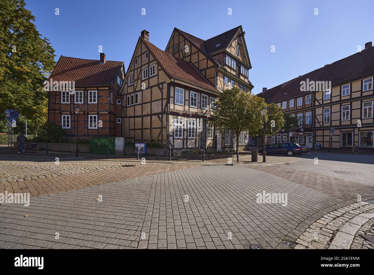 Case storiche in legno, alberi della città, strade di pavimentazione in cemento, luce laterale, retroilluminazione, cielo blu senza nuvole, intersezione di Kleiner Plan st Foto Stock