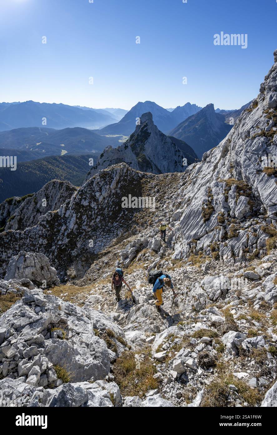 Alpinisti su un sentiero escursionistico, paesaggio montano autunnale, salita alla grosse Arnspitze, Arnplattenspitz sul retro, vicino a Scharnitz, Baviera, Ger Foto Stock