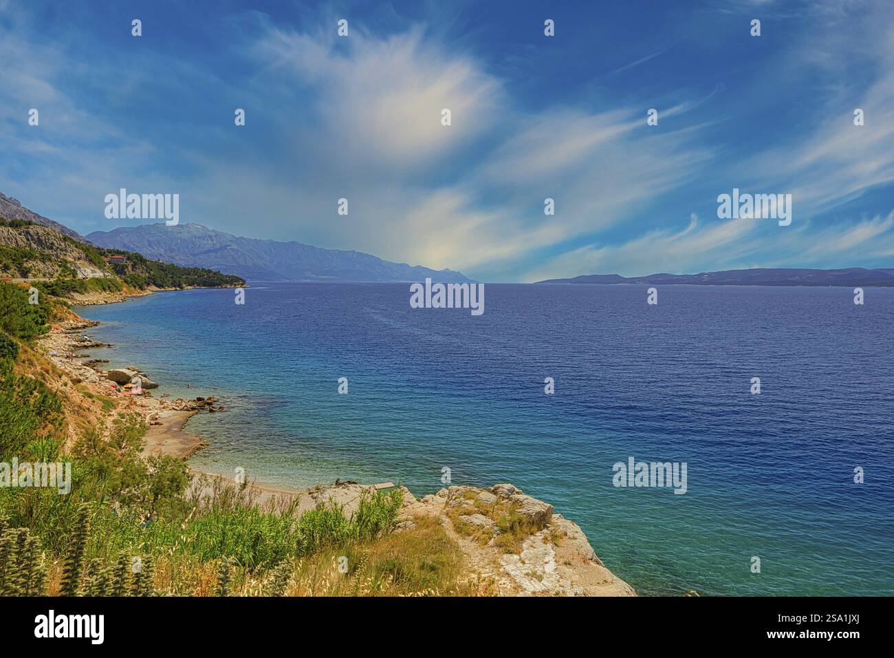 Paesaggio costiero con mare blu e costa verde, cielo tranquillo con zone nuvolose, costa di Makarska Dalmazia Croazia Foto Stock