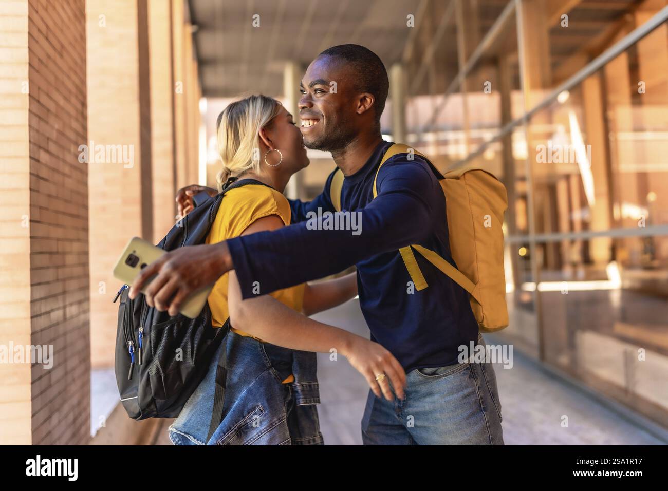 Gli studenti multirazziali sorridono felicemente mentre accolgono e salutano il campus universitario Foto Stock