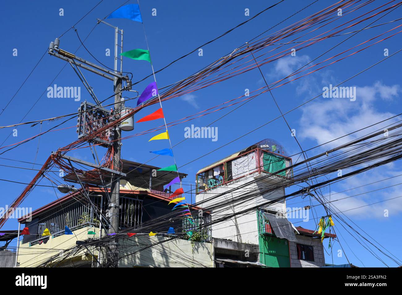 FILIPPINE, Manila, Quezon City, linee di trasmissione di potenza caotiche e capanne, palo con misuratori di potenza Foto Stock