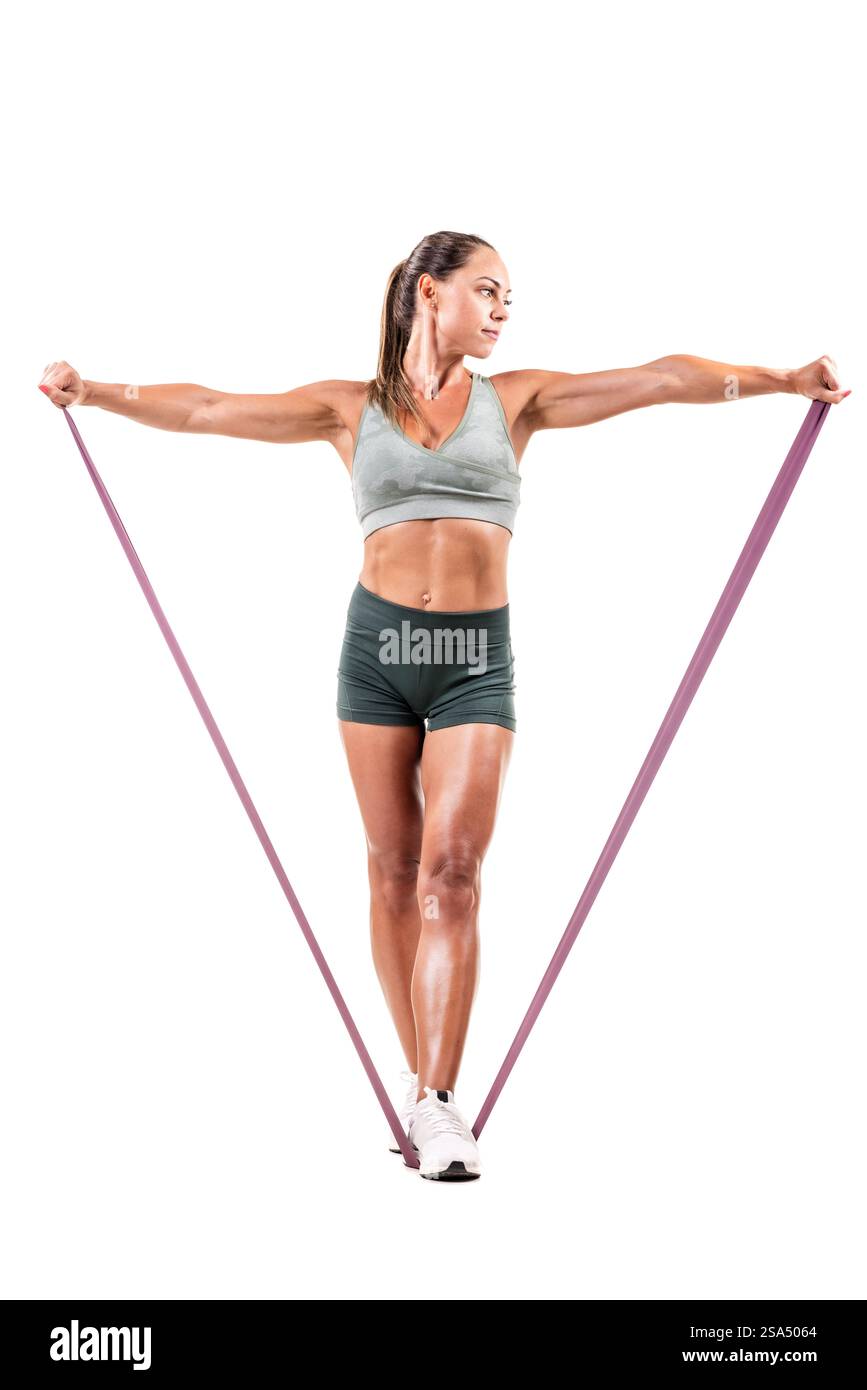Una donna in forma si esercita usando una fascia di resistenza, mostrando forza, fitness e concentrazione. Ideale per promuovere la forma fisica, la vita sana, l'esercizio fisico Foto Stock
