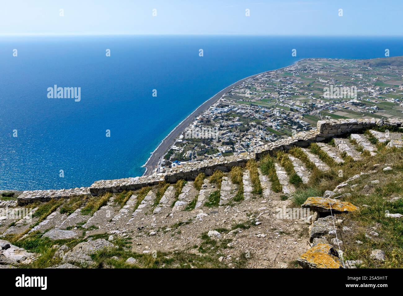 Vista dall'antica Thira che si affaccia su Perissa e sul Mar Egeo a Santorini, Grecia. Un sito storico con splendidi paesaggi costieri e vulcanici. Foto Stock