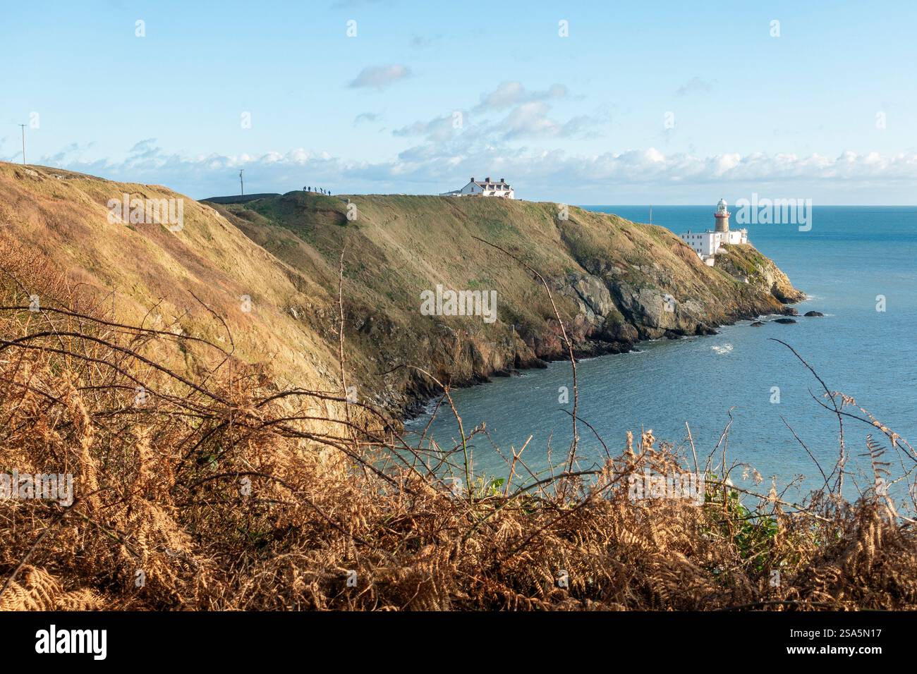 Il faro di Baily nella Doldrum Bay si affaccia sulle tranquille acque che circondano Howth, in Irlanda, in una giornata di inverni limpidi Foto Stock