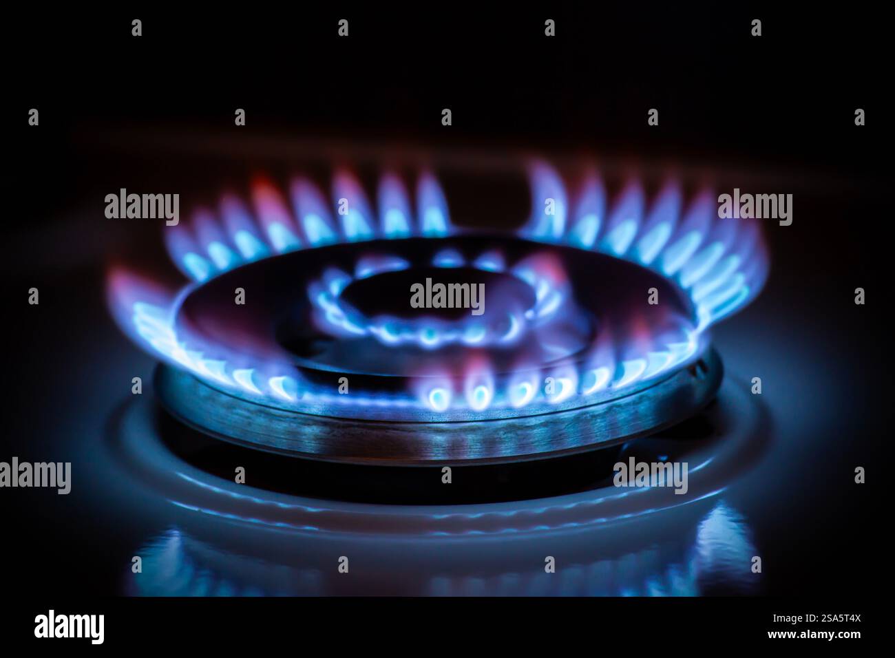 Fornello a gas con fiamma blu al buio Foto Stock