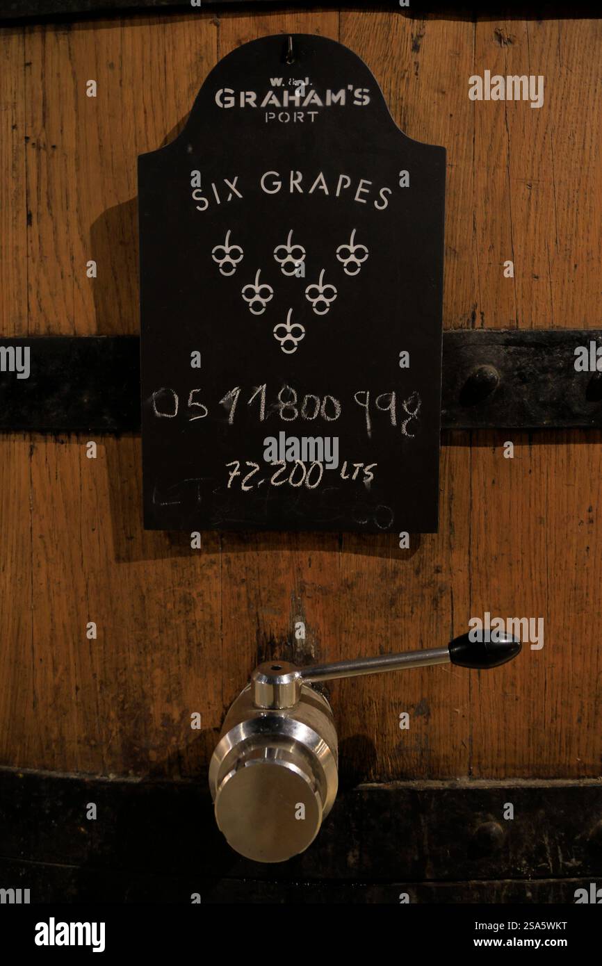 L'etichetta di sei vini porto di uve sopra la valvola di una grande botte di vino al Graham's Port Lodge. Porto. Portogallo Foto Stock