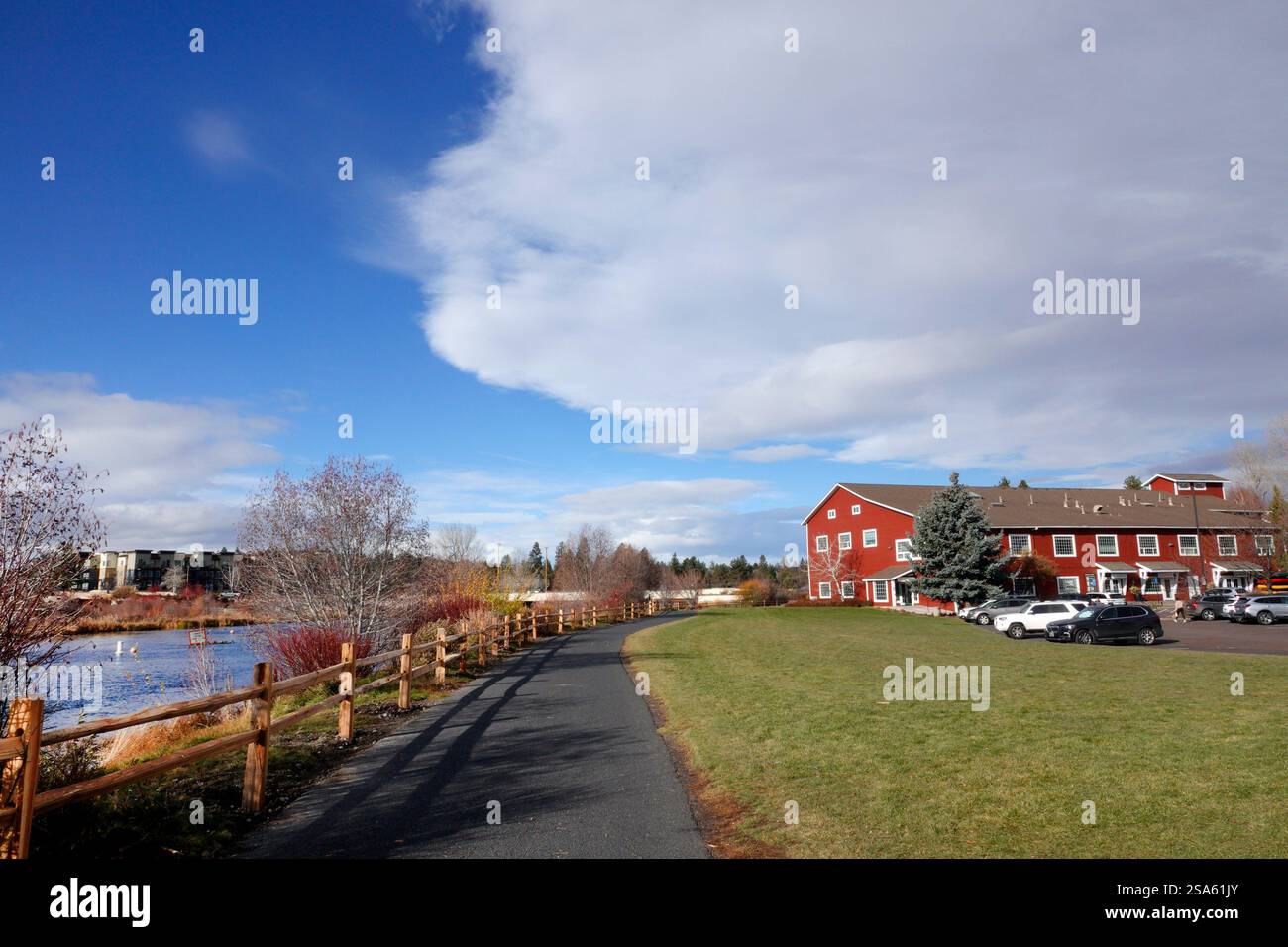 Passerella pavimentata lungo il fiume Deschutes nell'area commerciale Old Mill di Bend, Oregon. Foto Stock